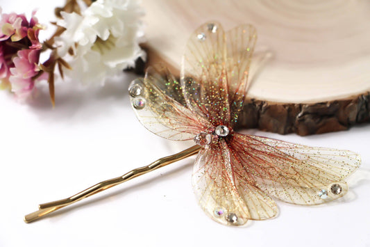 Dettaglio forcina gioiello per capelli con ali color arancio e cristalli Swarovski