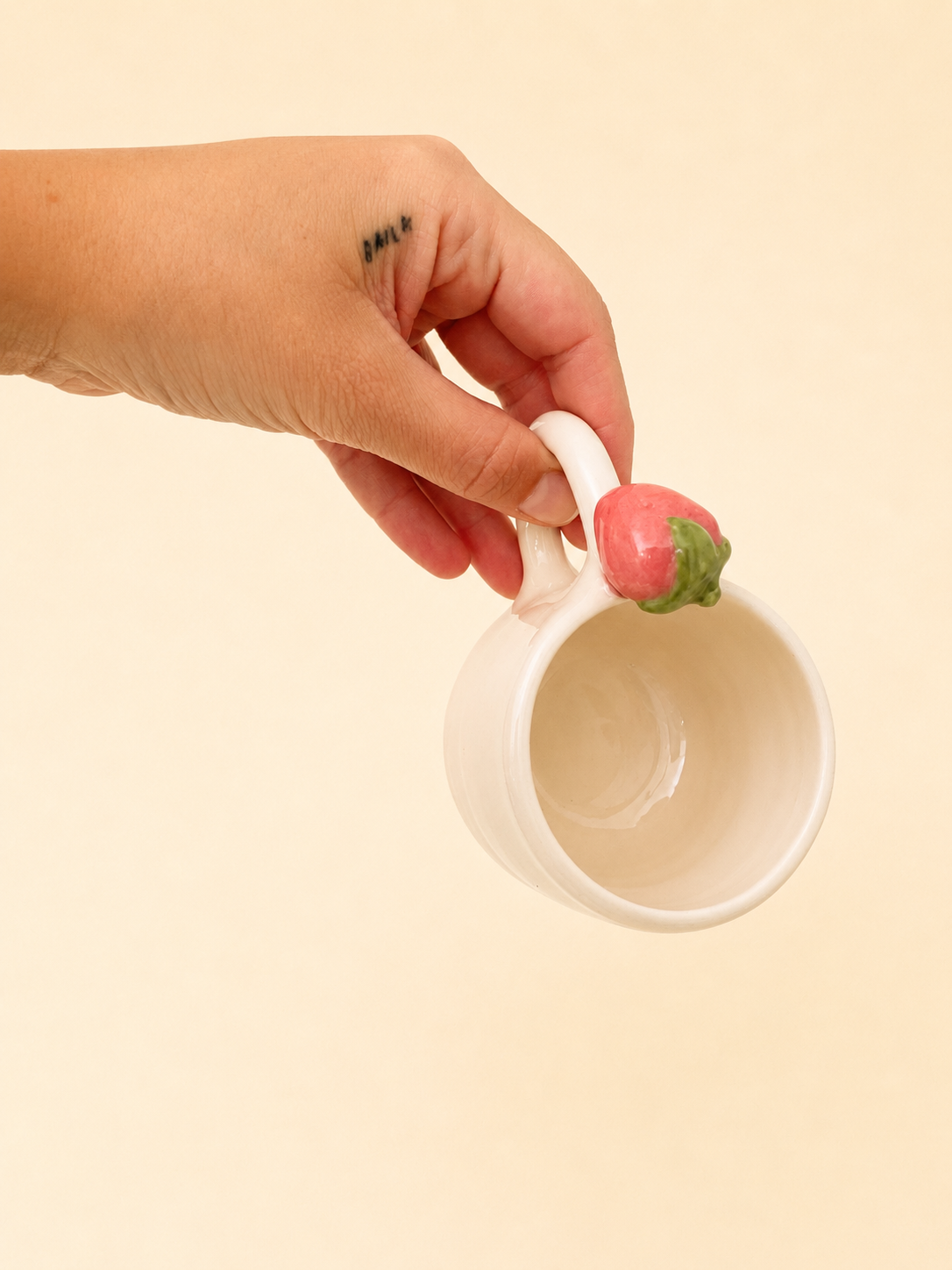 Tazzina in ceramica crema fatta a mano con dettaglio fragola